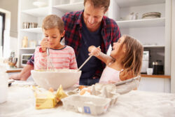 Vater macht ein süsses Dessert mit seinen Kindern