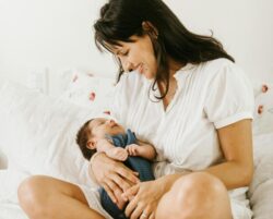 Mutter lächelt ihr Baby an. Dieses Lächeln bildet das erste, zarte Fundament für die kreative Entdeckungsfreude des Kindes.